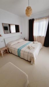 um quarto branco com 2 camas e uma janela em Lotto 16 em Olbia