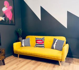 a yellow couch in a room with a blue wall at KVM - Lavish Style Apartment - Modern 2 Bedroom Apartment in Bayard FREE Parking - KVM Lavish Style Apartment by KVM Stays in Peterborough