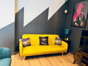 a yellow couch in a living room with a wall at KVM - Lavish Style Apartment - Modern 2 Bedroom Apartment in Bayard FREE Parking - KVM Lavish Style Apartment by KVM Stays in Peterborough