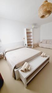 um quarto com uma grande cama branca com toalhas em Lotto 16 em Olbia