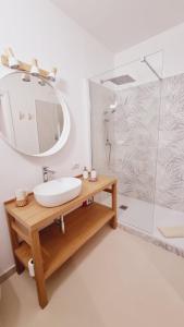 uma casa de banho com um lavatório, um espelho e um chuveiro em Lotto 16 em Olbia