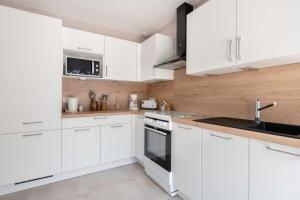 a white kitchen with white cabinets and a sink at Incroyable emplacement à 110m de la plage in La Turballe +9 photos