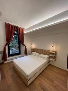 sypialnia z dużym białym łóżkiem i oknem w obiekcie Suite The Brick w Turynie