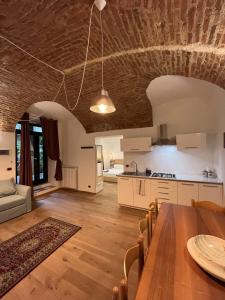 Suite The Brick في تورينو: مطبخ وغرفة معيشة مع طاولة خشبية وغرفة طعام