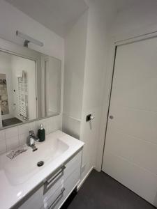 een witte badkamer met een wastafel en een spiegel bij Suite The Brick in Turijn