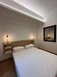 una camera da letto con un grande letto bianco con due cuscini di Suite The Brick a Torino