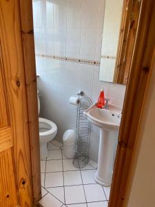 a bathroom with a toilet and a sink at The Cliffs of Moher House, Doolin in Droíchead an Chláir