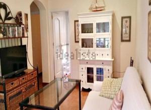 ein Wohnzimmer mit einer Couch und einem Glastisch in der Unterkunft Villas de Islantilla in Isla Cristina