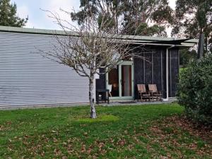 a small tree in a yard next to a house at Beautiful Rural Oasis in Upper Hutt