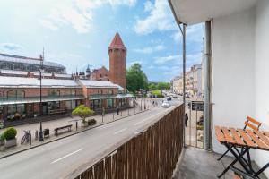 d'un balcon donnant sur une rue avec une tour d'horloge. dans l'établissement Bell Tower Old Town Gdańsk Apartment, à Gdańsk