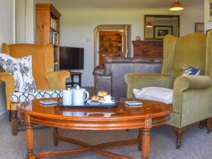 a living room with a coffee table and chairs at Thornes Farm Annexe in West Quantoxhead