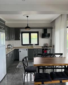 eine Küche mit einem Holztisch und einem Esszimmer in der Unterkunft Sapanca Çeşme Villaları in Feyziye