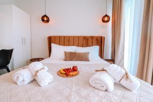 a bed with towels and a plate of fruit on it at Sithon Diamond Suites 2 in Nikiti +19 photos