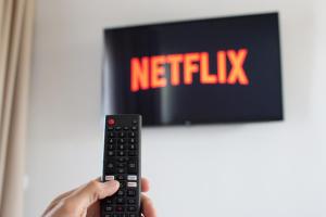 a person holding a remote control in front of a television at Sithon Diamond Suites 2 in Nikiti