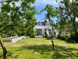 een uitzicht op een wit huis met een tuin bij Tiny house in tuin van de statige villa Mariahof in Dordrecht