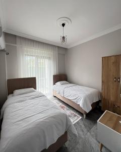 1 Schlafzimmer mit 2 Betten und einem Fenster in der Unterkunft Sapanca Çeşme Villaları in Feyziye