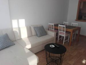 a living room with a white couch and a table at Apartamento El Diario in Adra
