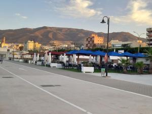 a parking lot with tables and blue umbrellas at El Diario-Royal in Adra