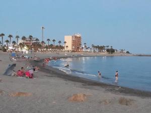 a group of people playing in the water at the beach at El Diario-Royal in Adra