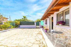 une terrasse avec une table et des chaises ainsi qu'une maison dans l'établissement Posizione strategica, Wi-Fi e parcheggio gratuito, à Sassari