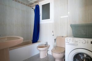 een badkamer met een toilet, een wastafel en een wasmachine bij AT111 Vistas frontales a la playa la Paella in Torredembarra +31 foto's