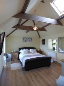 a bedroom with a large bed and wooden beams at Cosy Studio Cottage in Lincoln