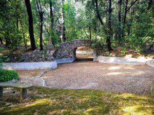 un pont en pierre dans un parc avec un banc dans l'établissement Il mondo di Giada, à Vicopisano