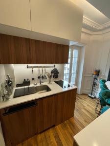 a kitchen with wooden cabinets and a sink at Appartement en hypercentre Mont Dore in Le Mont-Dore