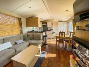 a living room with a couch and a table and a kitchen at Brilliant 8 Berth Caravan With Decking At Haven Caister Beach Ref 30055p in Great Yarmouth