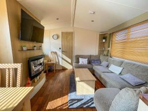 a living room with a couch and a flat screen tv at Brilliant 8 Berth Caravan With Decking At Haven Caister Beach Ref 30055p in Great Yarmouth