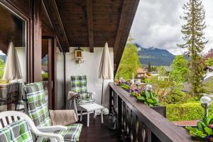 a porch with chairs and umbrellas on a house at Aurikel in Garmisch-Partenkirchen