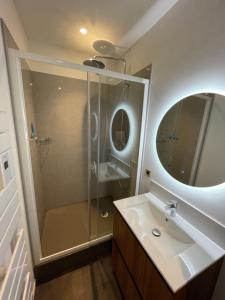 a bathroom with a shower and a sink and a mirror at Appartement en hypercentre Mont Dore in Le Mont-Dore