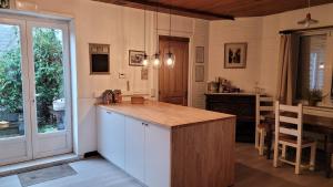 cocina con encimera, mesa y ventana en Troubadour24, en Poperinge