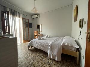ein Schlafzimmer mit einem weißen Bett und einem Fenster in der Unterkunft The Beehive 2 in Mytilini