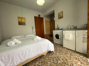 - une chambre avec un lit et un lave-linge dans l'établissement The Beehive 2, à Mytilène