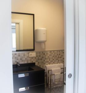 a bathroom with a sink and a mirror at Astorga suites in Astorga