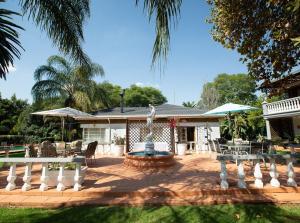 a house with a fountain in the middle of a yard at Golden Candle Guest House in Roodepoort
