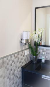 a bathroom with a counter with a vase of flowers at Astorga suites in Astorga