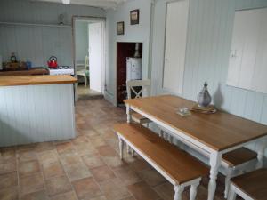 een keuken met een tafel en banken in een kamer bij The Drovers Cabin in Kirkcudbright