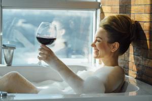 a woman sitting in a bath tub holding a glass of wine at Pasaport Pier Hotel in İzmir +35 photos