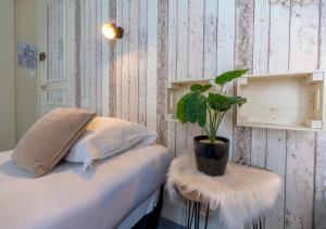 a potted plant sitting on a table next to a bed at Nouvel Hôtel in Paris