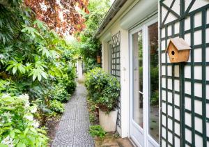a garden path leading to a house with a birdhouse at Nouvel Hôtel in Paris