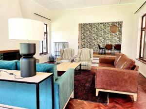 a living room with a blue couch and chairs at Hydrangea Guest House in Nottingham Road