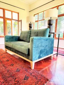 a blue couch in a living room with a red rug at Hydrangea Guest House in Nottingham Road