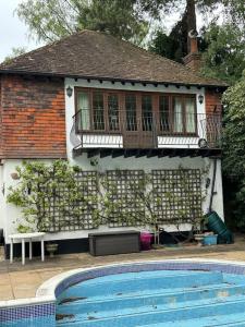 a house with a swimming pool in front of it at Maywoods Apartment in Virginia Water