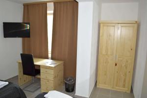 1 dormitorio con escritorio, 1 cama y armario en Zwei Raben Pension, en Mainz