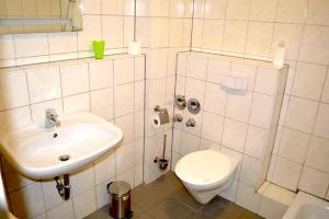 a white bathroom with a sink and a toilet at Zwei Raben Pension in Mainz