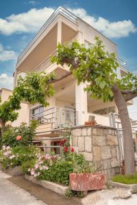 una casa bianca con alberi e fiori di fronte di Estell’s sweet luxury house a Volos