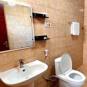 a bathroom with a sink and a toilet and a mirror at Juba Landmark Hotel in Juba