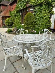 a white table and four chairs sitting around it at Maywoods Apartment in Virginia Water